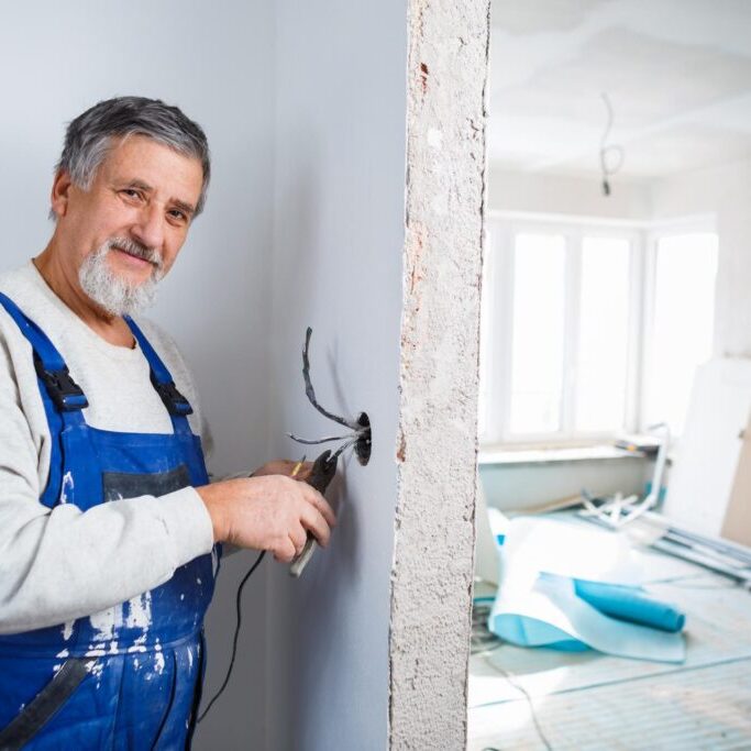 male worker cutting electrical wire